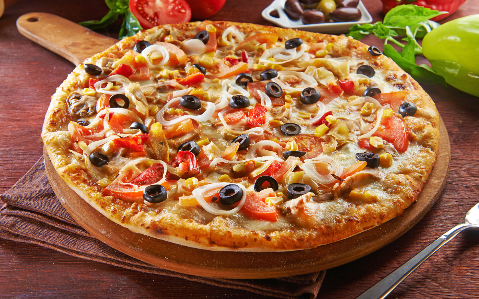 Большая пицца на доске с оливками и помидорами