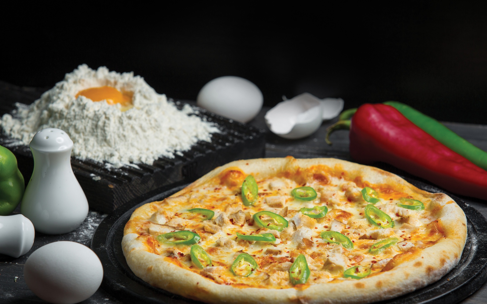 Пицца на столе с яйцами и перцем