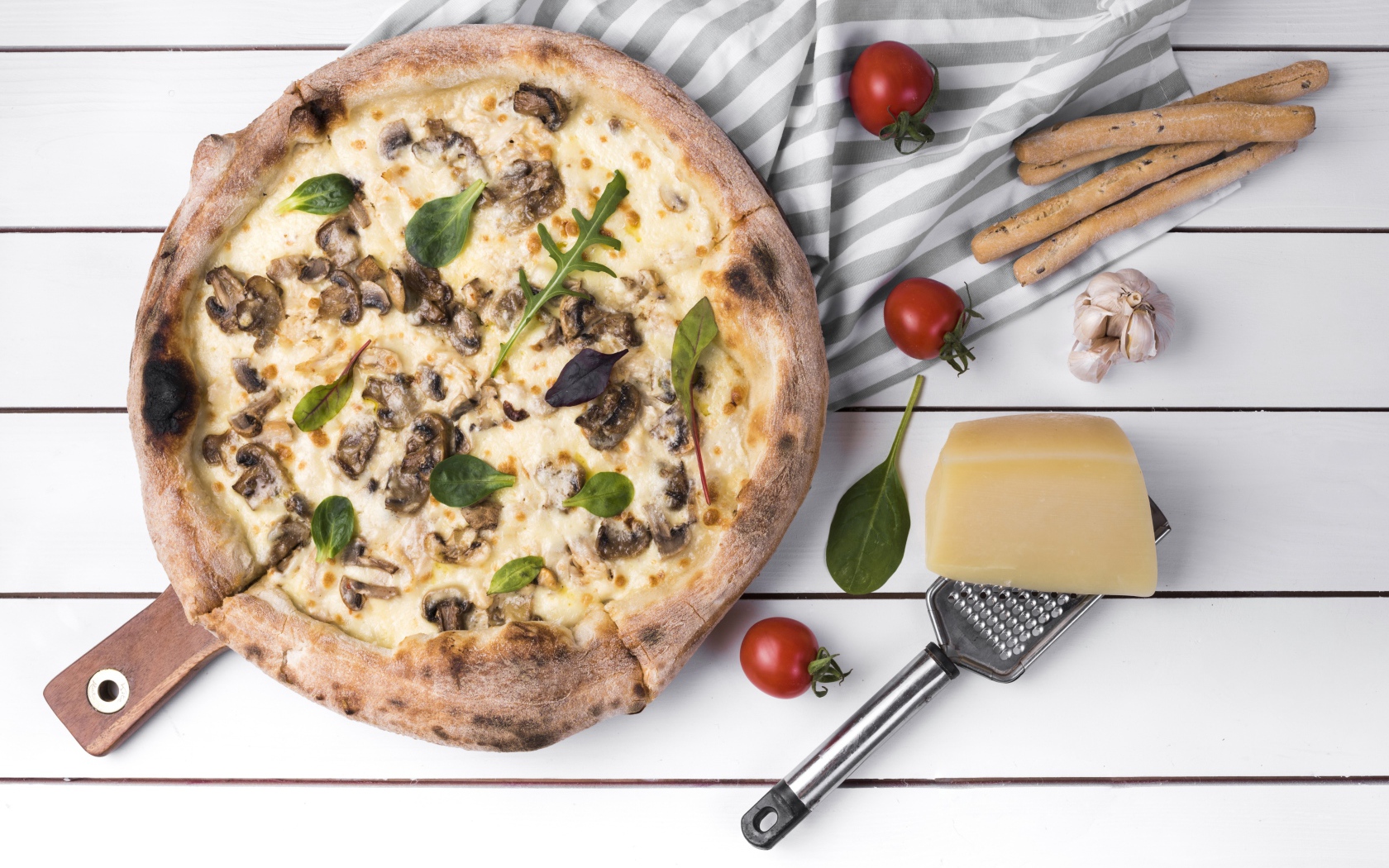 Пицца с грибами на столе с сыром и овощами