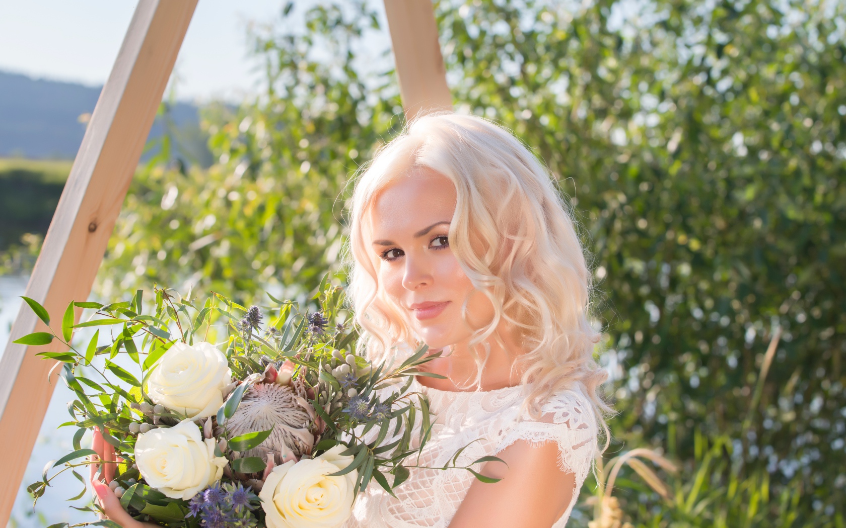 Красивая кареглазая блондинка с букетом в руках 