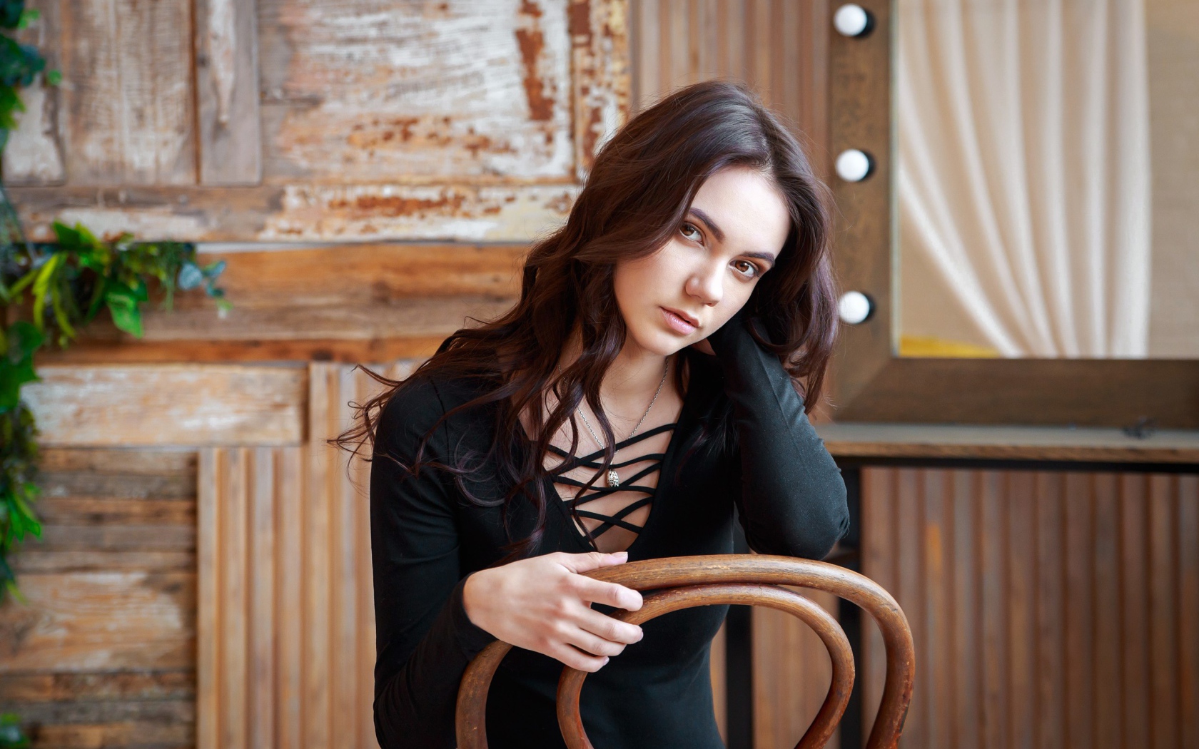 Красивая кареглазая девушка сидит на стуле