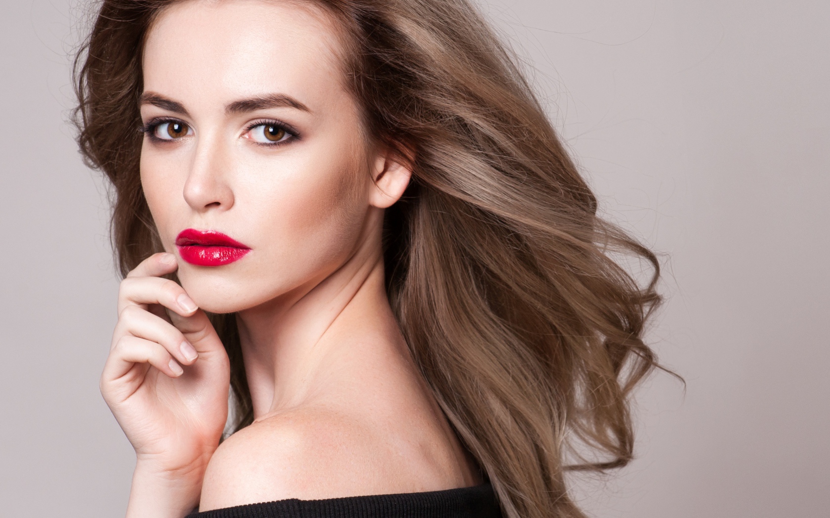 Красивая шатенка с красными губами на сером фоне