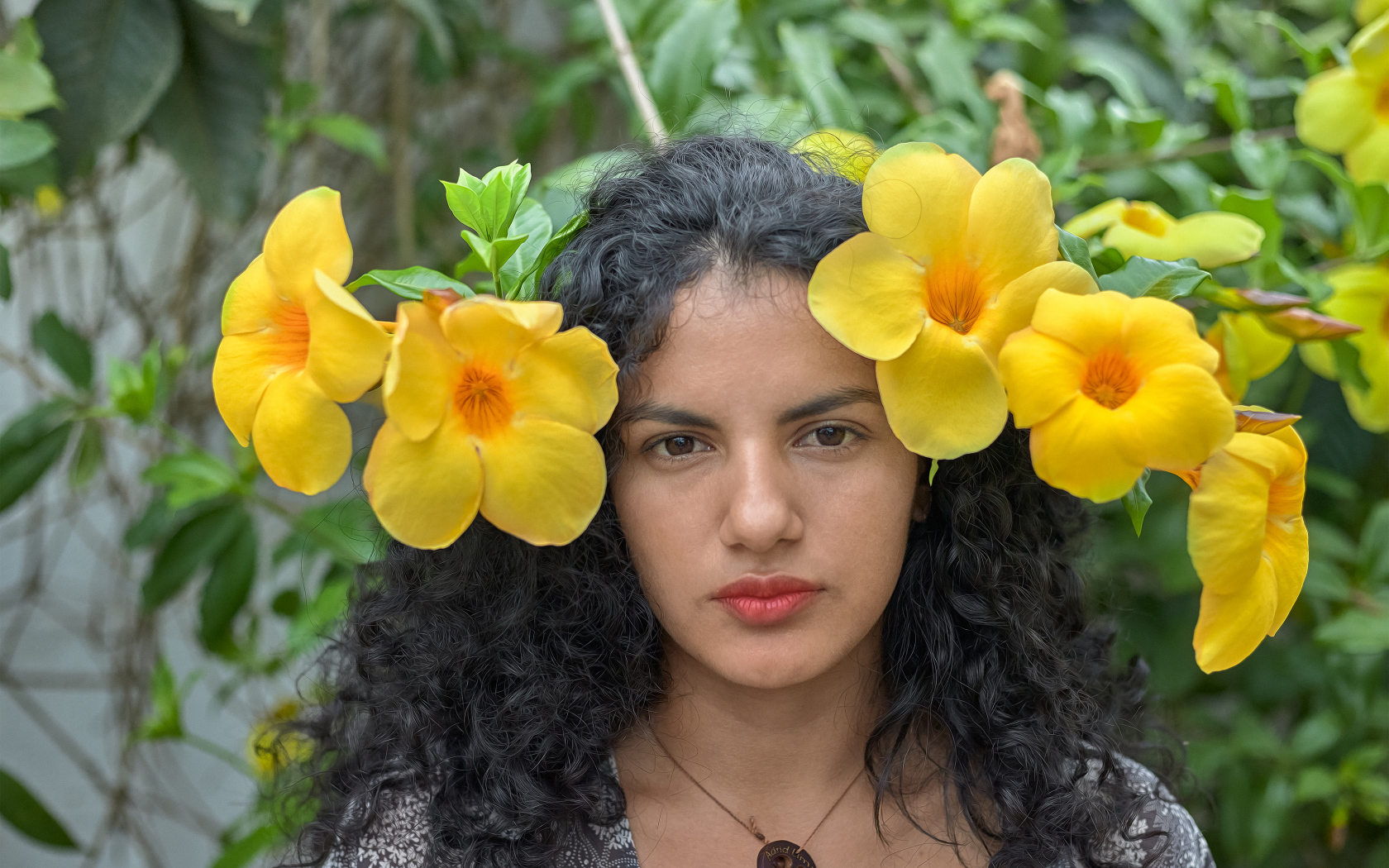 Красивая брюнетка с большими желтыми цветами в волосах 