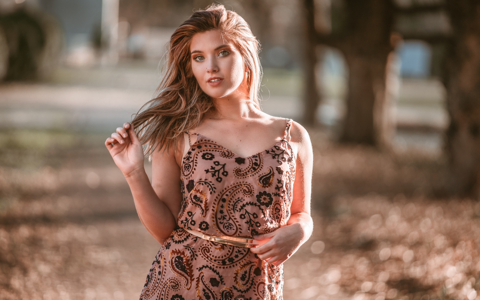 Красивая девушка в платье в лучах солнца летом