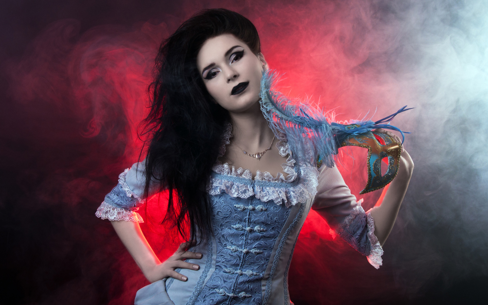 Красивая девушка в старинном платье с маской в руке