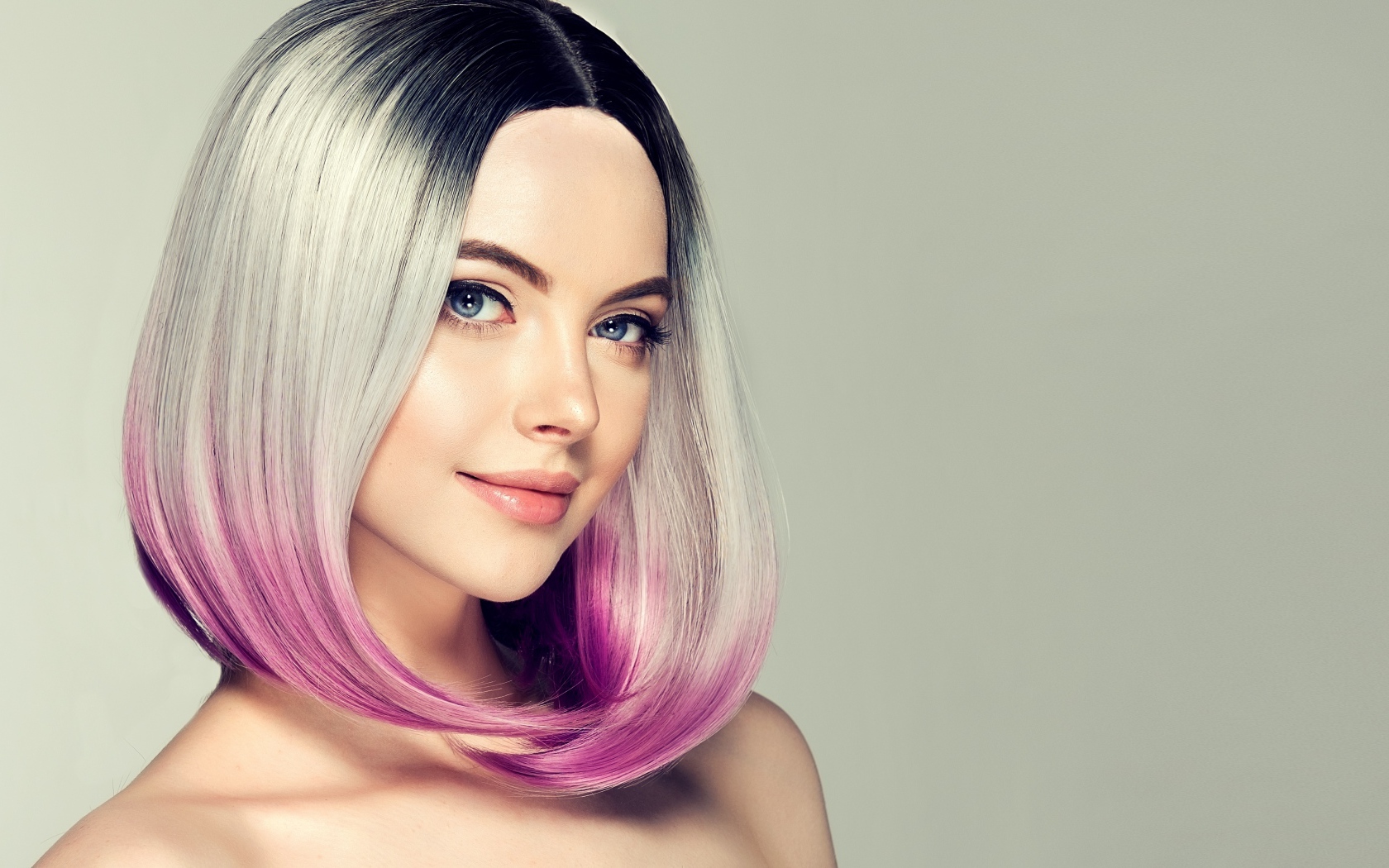 Красивая девушка с крашеными волосами на сером фоне