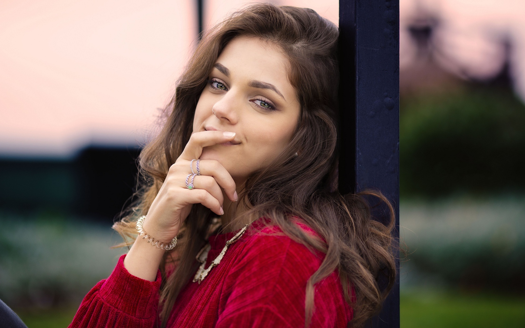 Красивая длинноволосая шатенка с рукой у лица