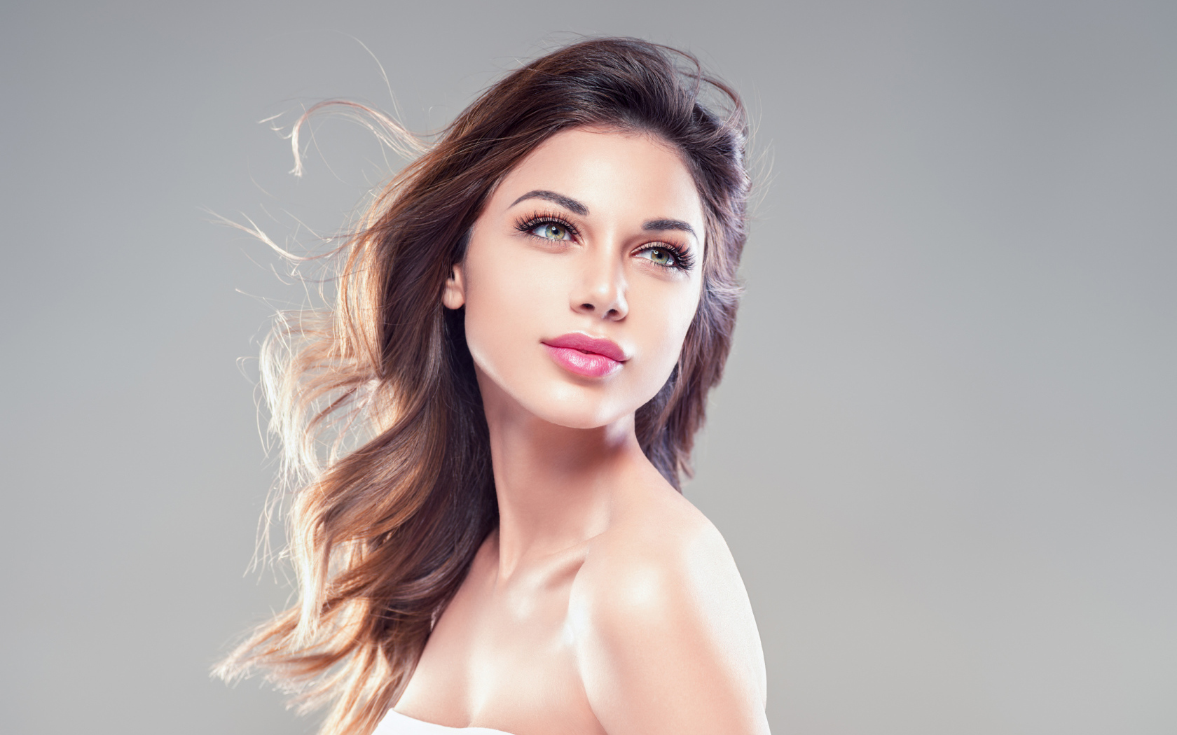 Красивая нежная девушка шатенка на сером фоне