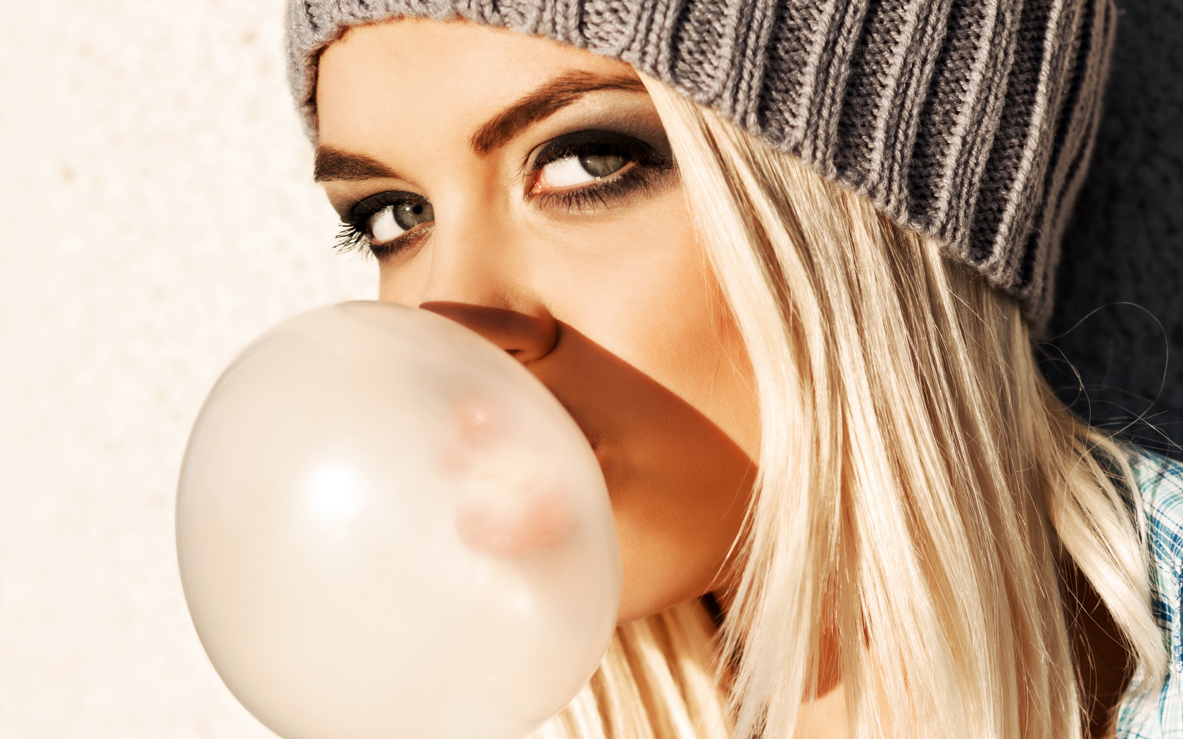 Девушка блондинка с жвачкой во рту крупным планом