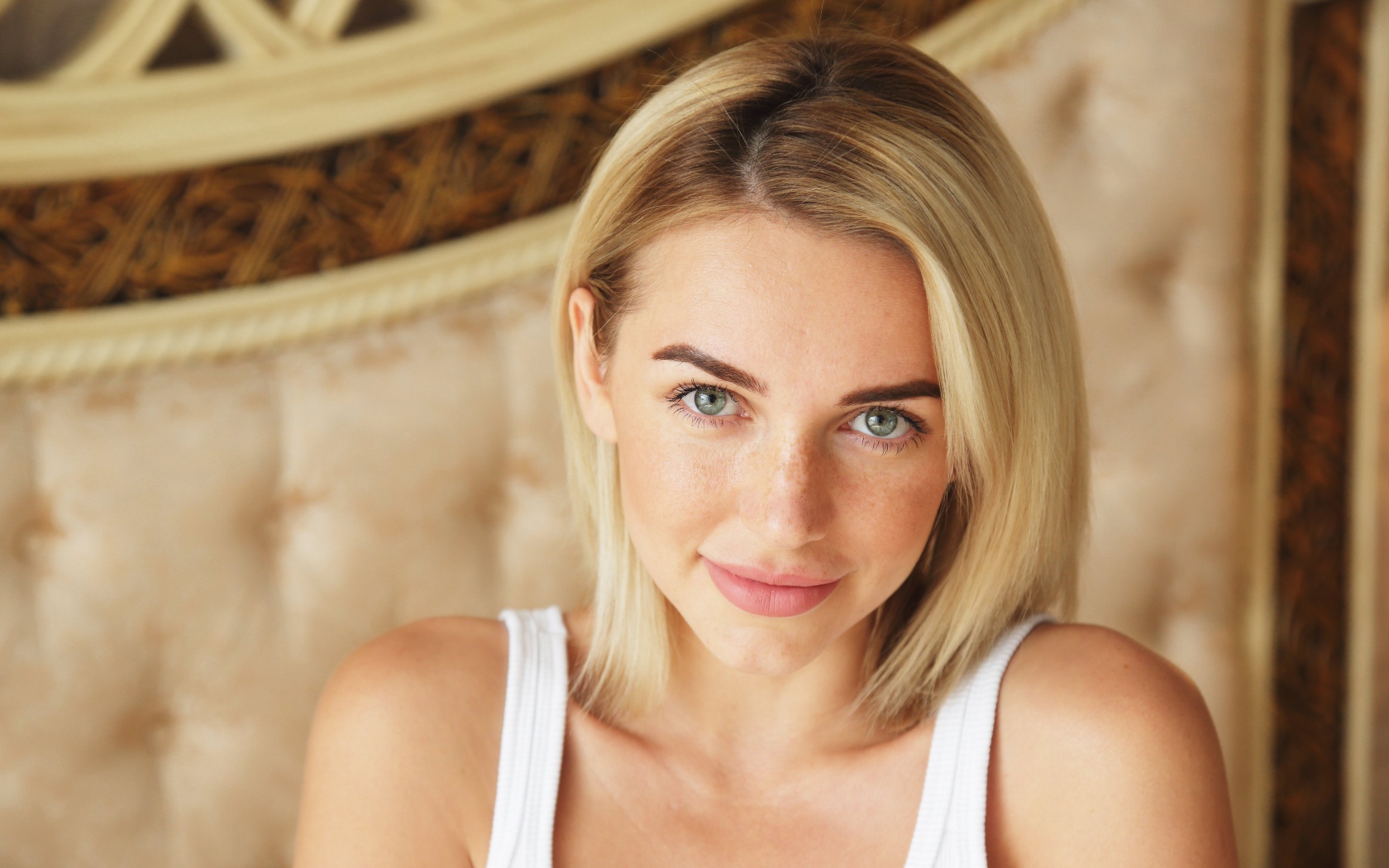 Нежная блондинка с зелеными глазами в белой майке