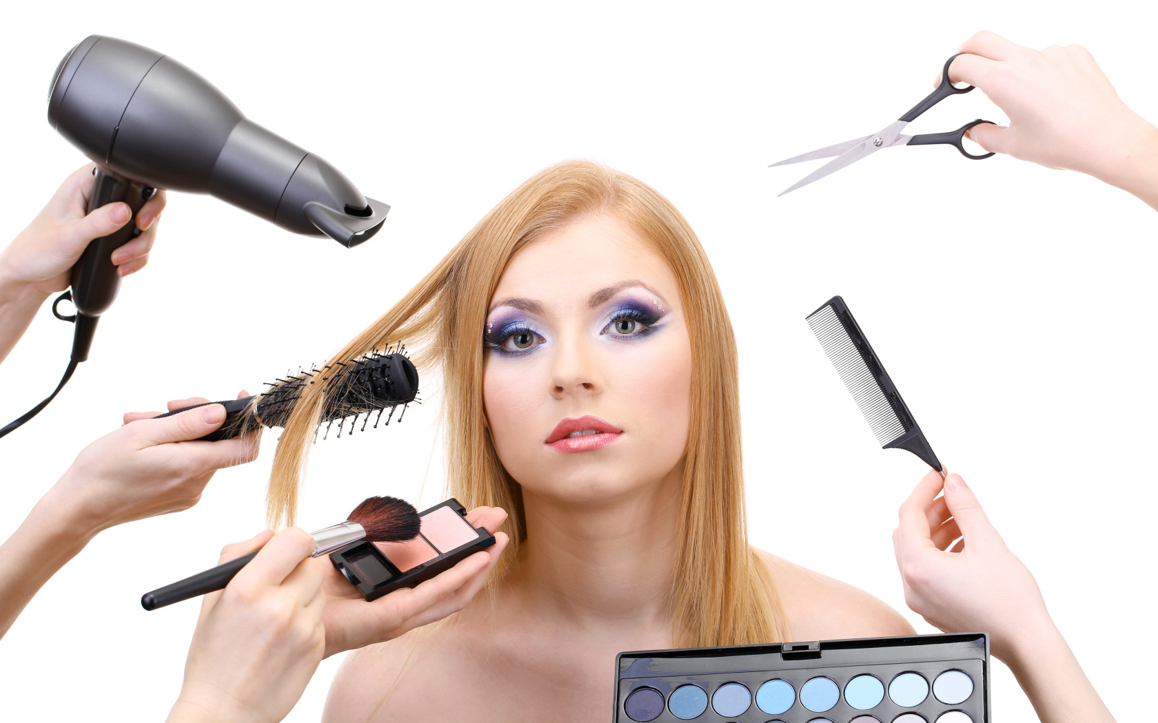 Девушке делают макияж и прическу на белом фоне