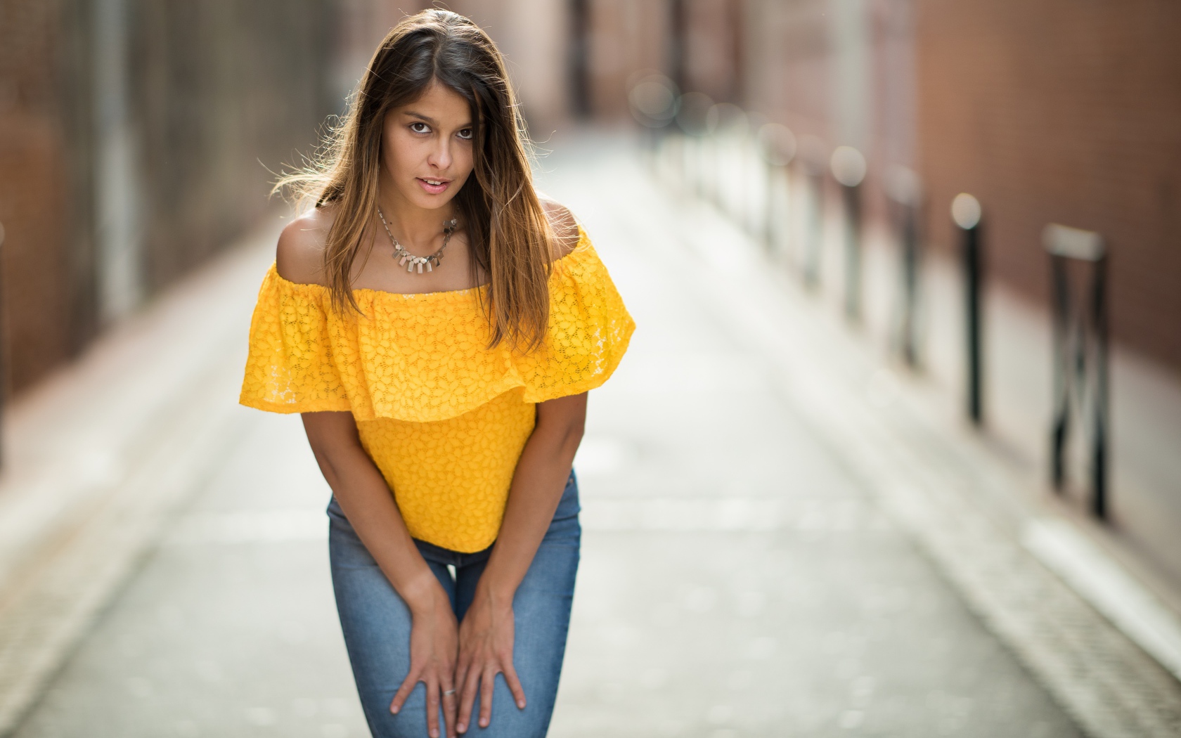 Девушка в джинсах стоит на улице 