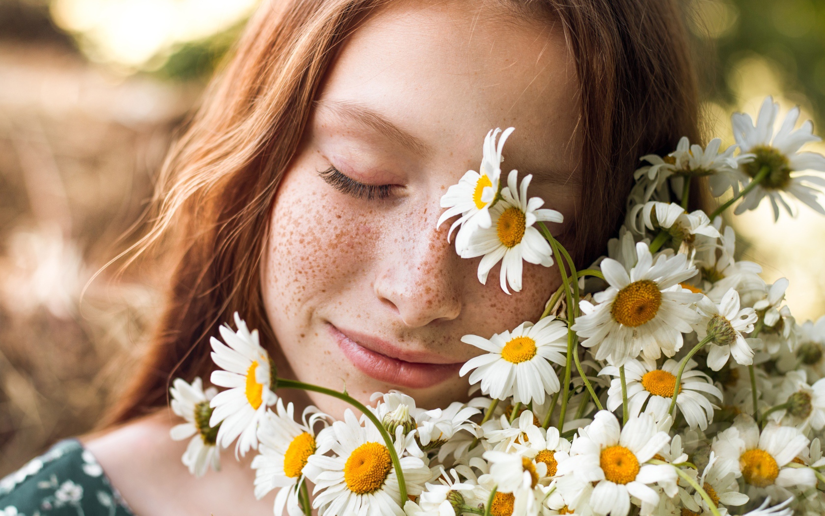 Рыжеволосая девушка с букетом ромашек