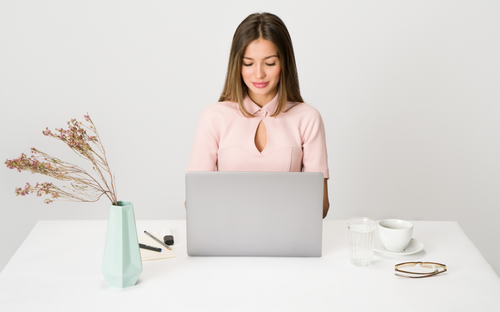 Умная девушка за ноутбуком на сером фоне