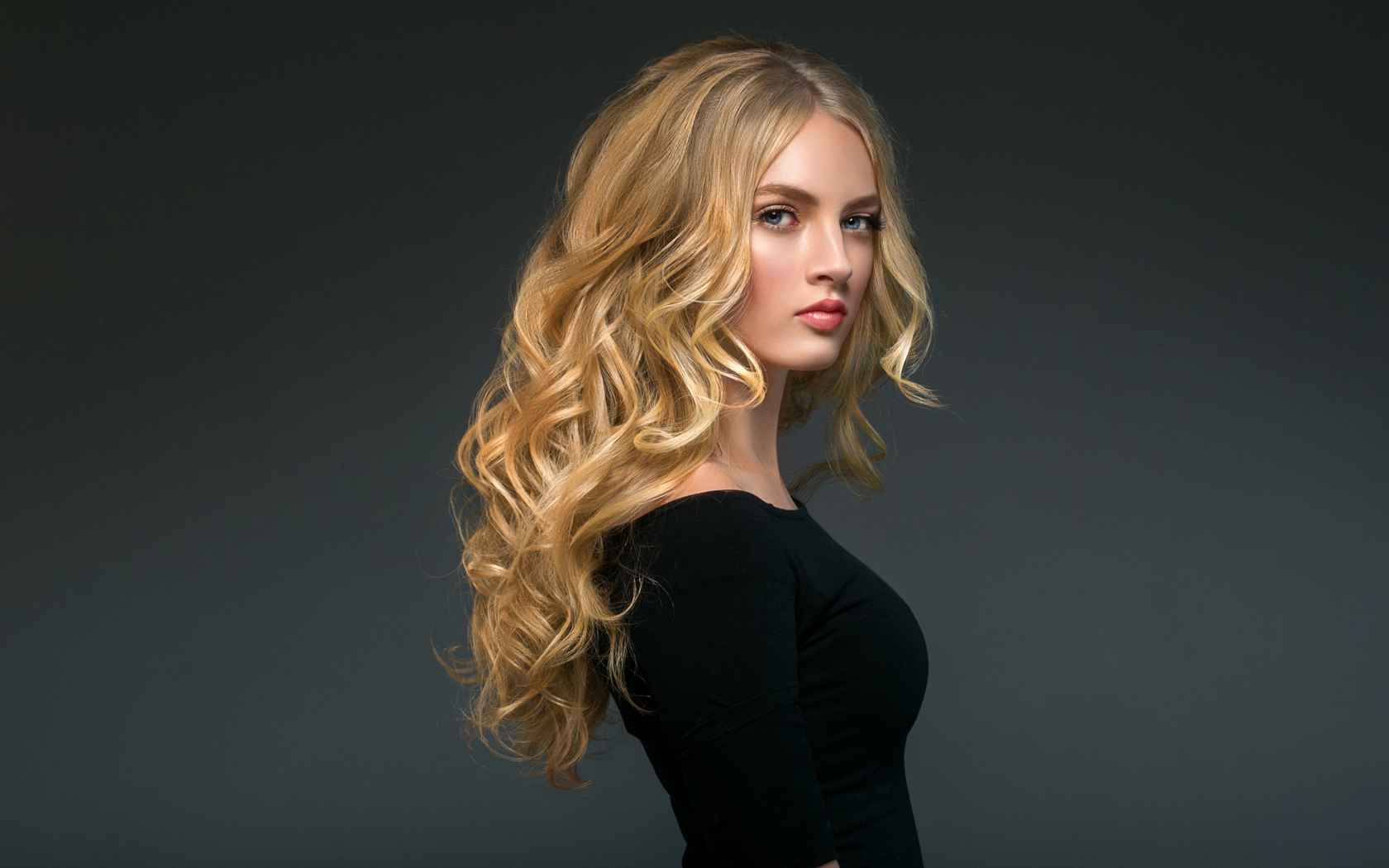 Стильная голубоглазая длинноволосая девушка в черном наряде