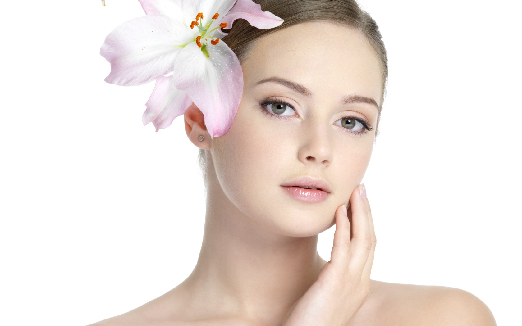 Нежная красивая девушка с лилией в волосах на белом фоне 