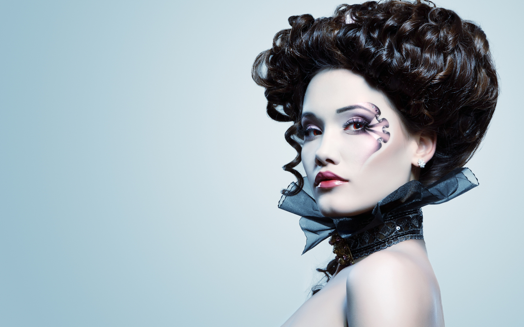 Девушка с необыной прической и макияжем на сером фоне