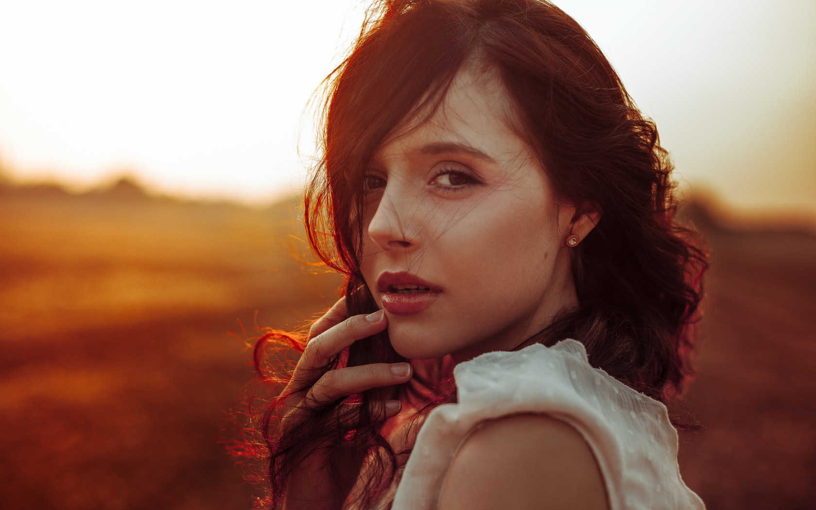 Ветер развивает волосы молодой девушки 