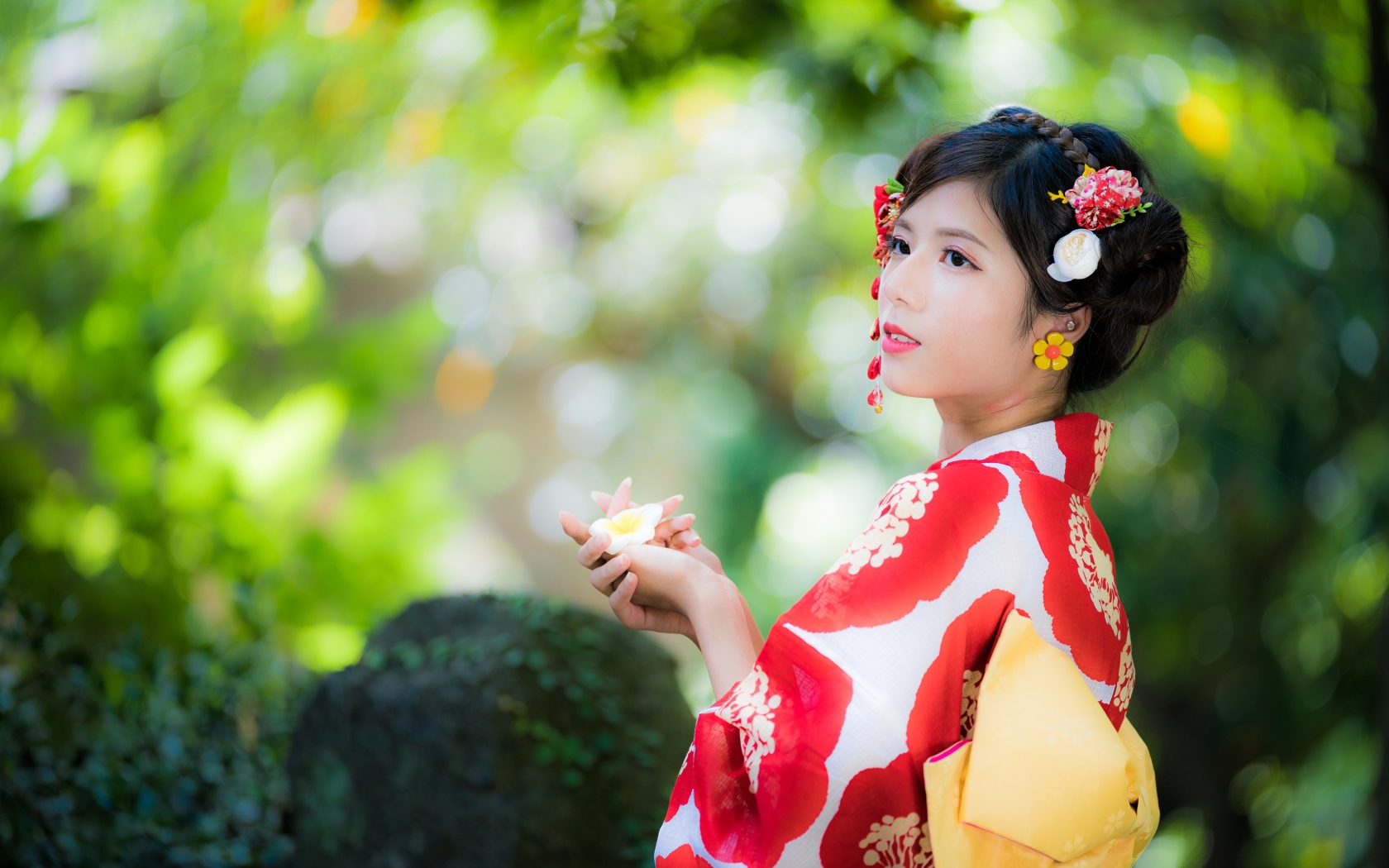 Молодая девушка азиатка в кимоно с цветами в волосах 