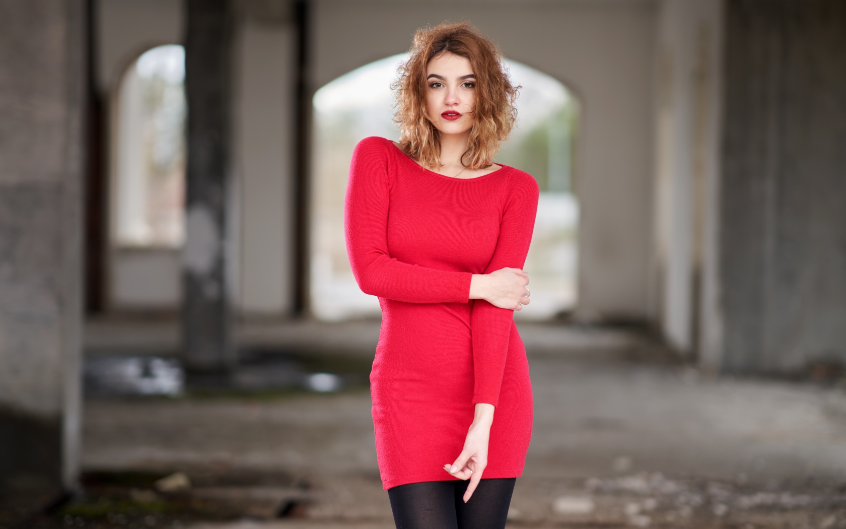 Молодая девушка в красном платье в старом здании