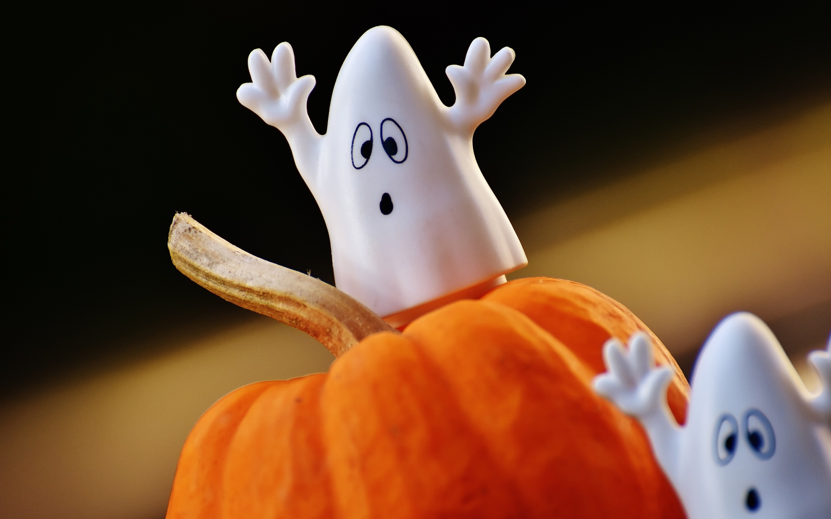Игрушечные призраки на тыкве на Хэллоуин 