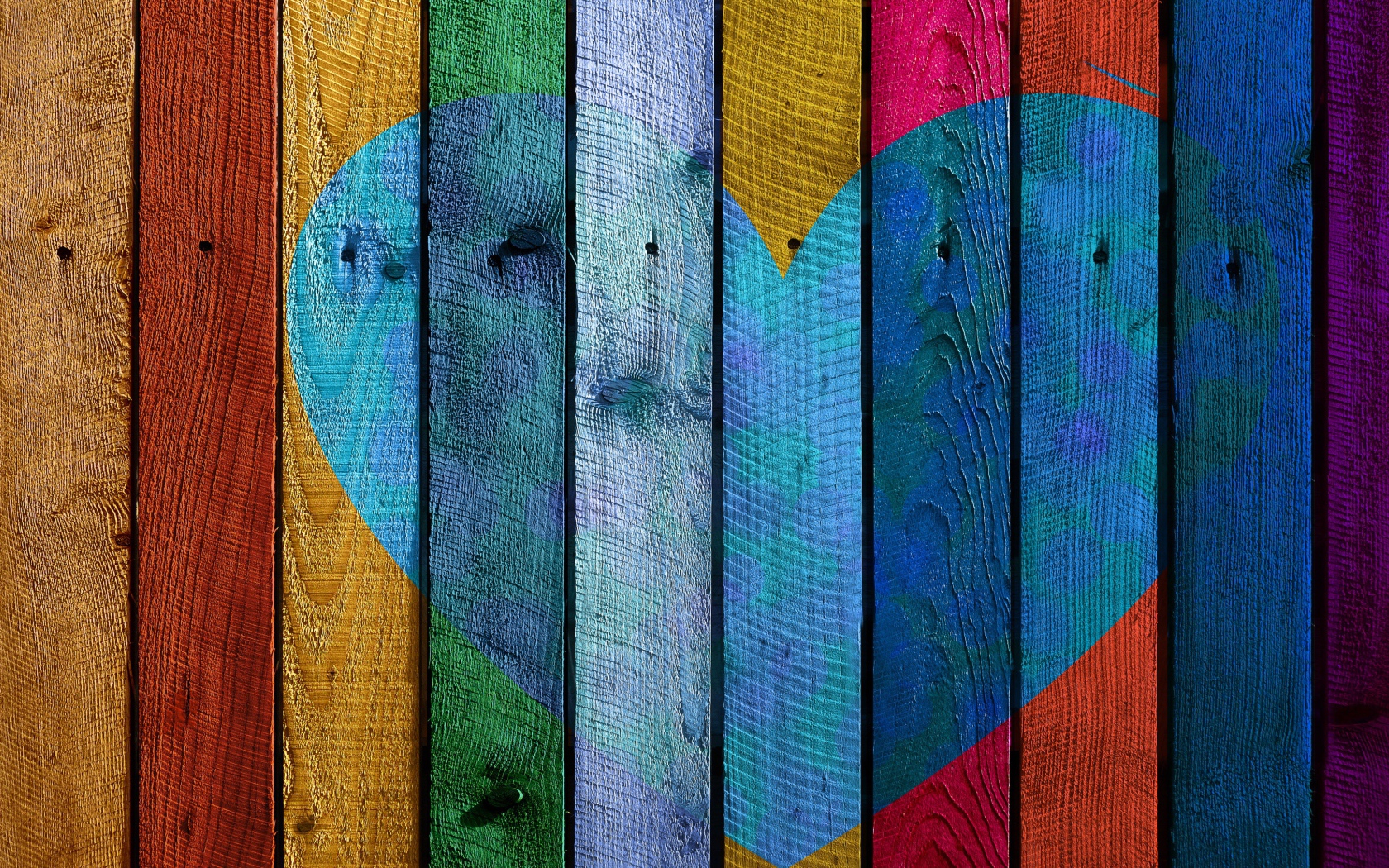 Blue heart painted on a colorful fence