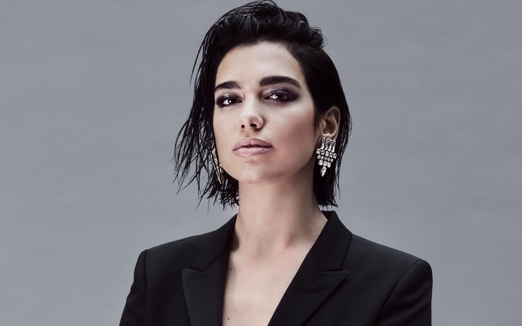 Стильная певица Дуа Липа на сером фоне