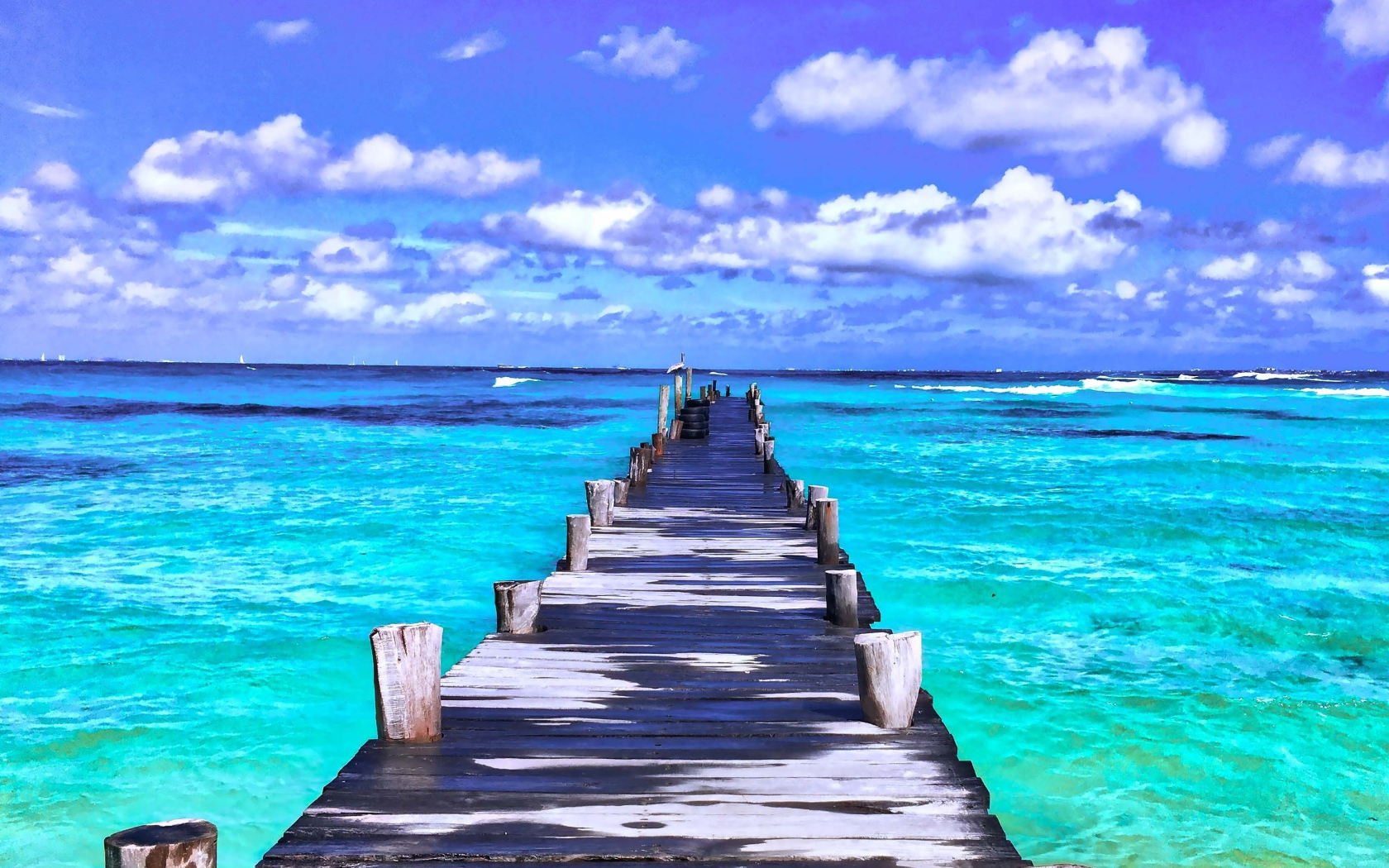 Деревянный мокрый пирс в голубом океане под красивым небом