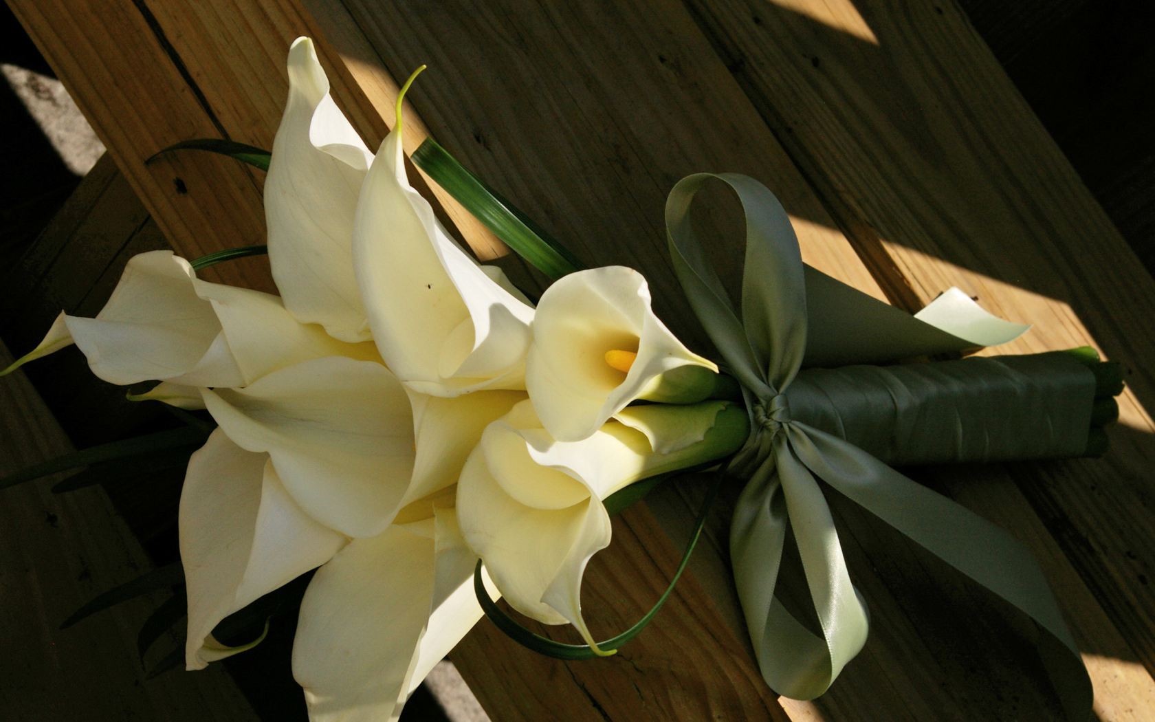 Букет белых калл на деревянной лавке