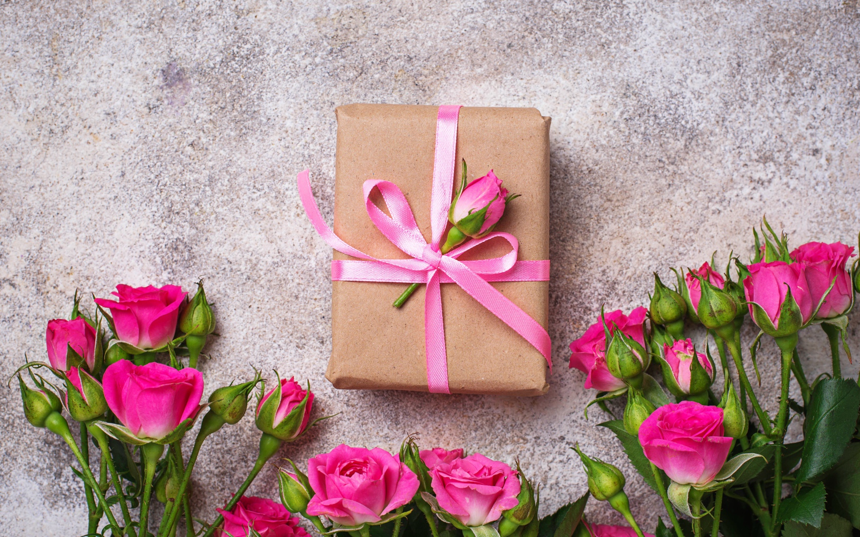 Подарок на сером фоне с букетом розовых роз