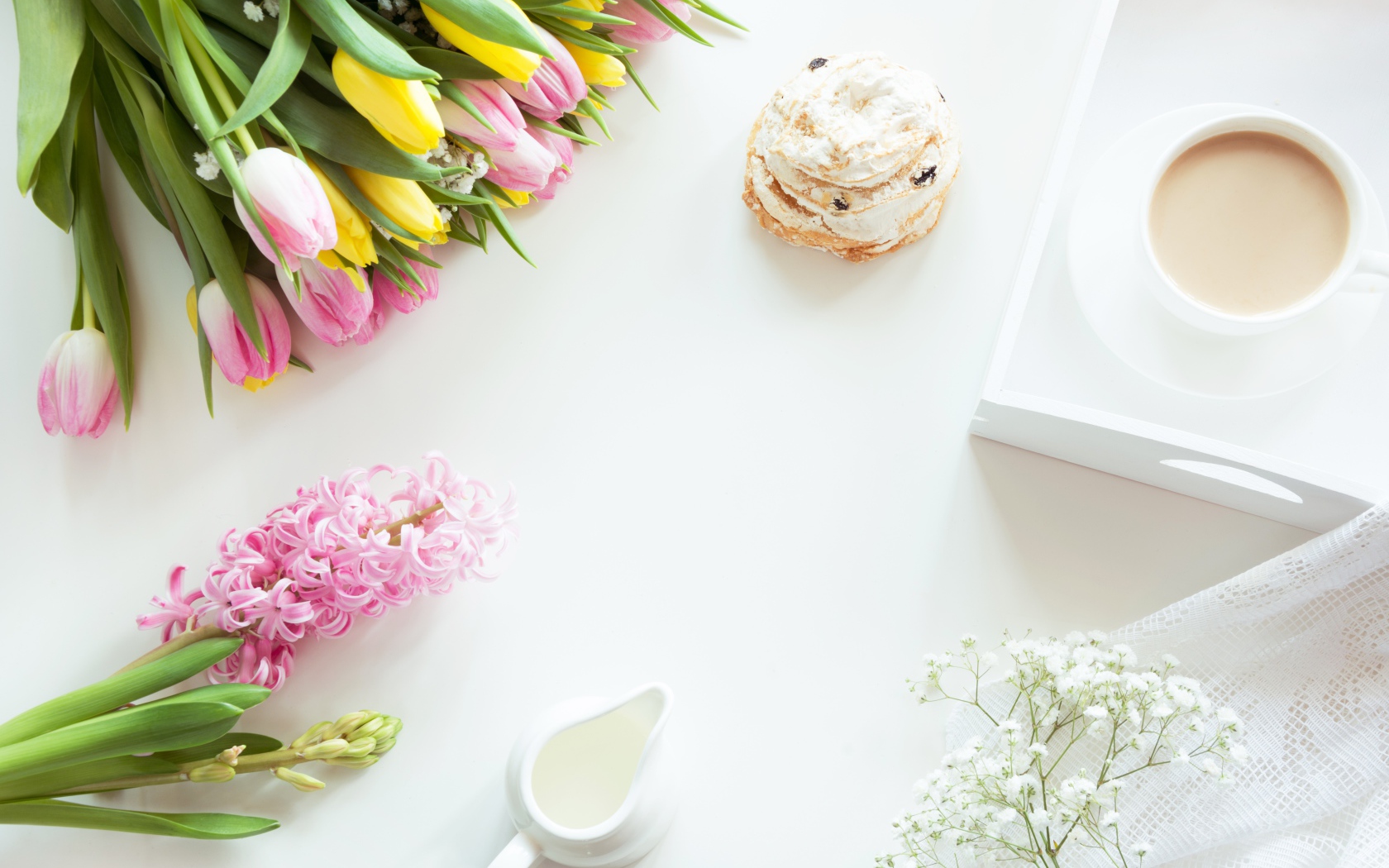 Букет тюльпанов и гиацинт на столе с пирожным и чашкой какао 
