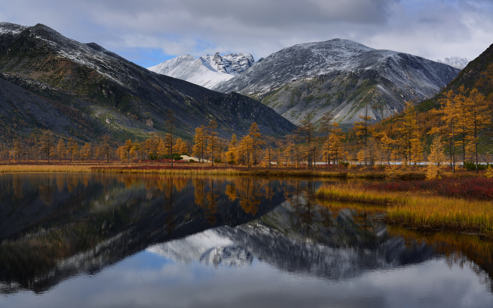 Горы отражаются в глади воды озера осенью