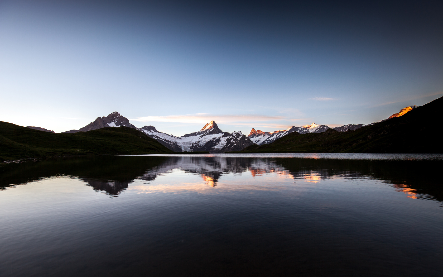 Calm mountain lake near the snowy mountains