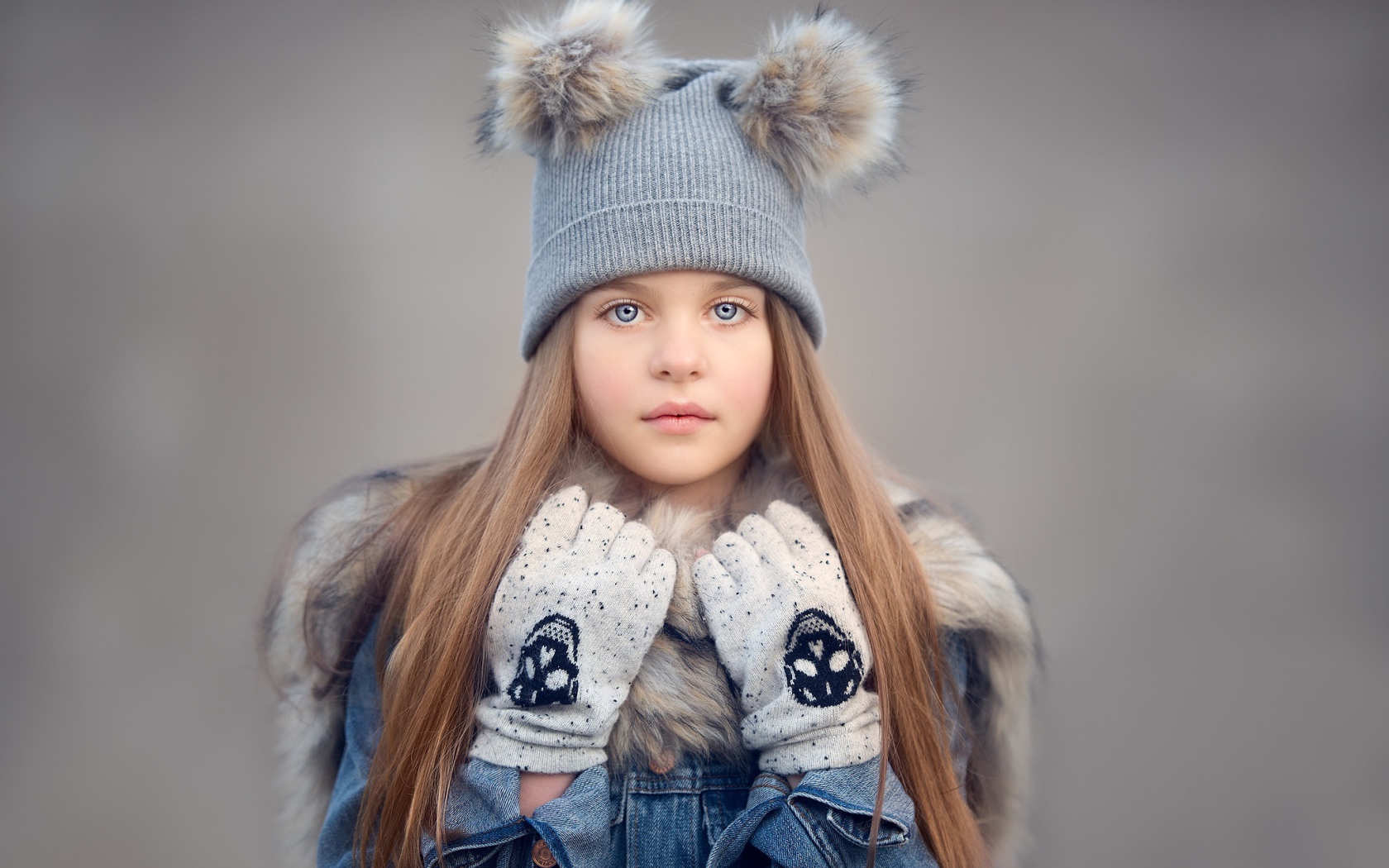 Красивая голубоглазая девочка в теплой шапке