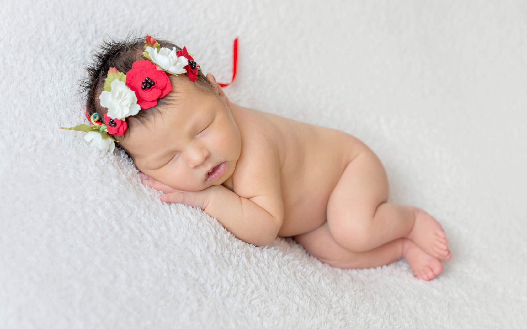 Грудная спящая девочка с венком на голове 