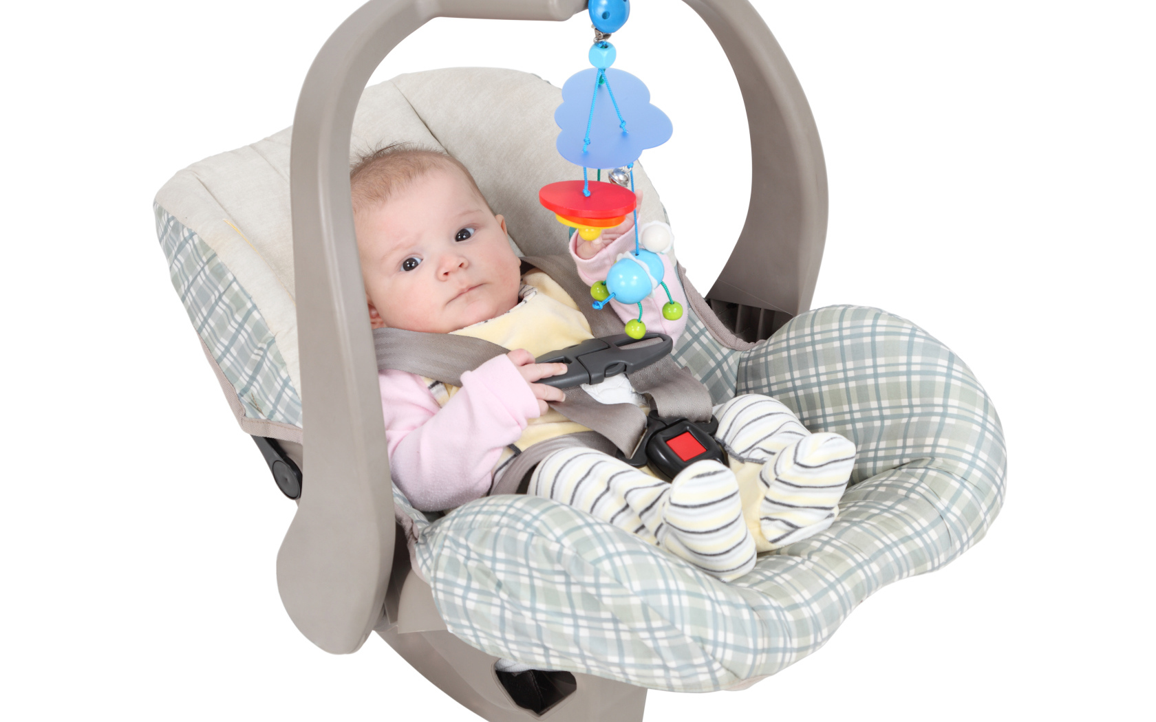 Маленький грудной ребенок в автомобильном кресле на белом фоне