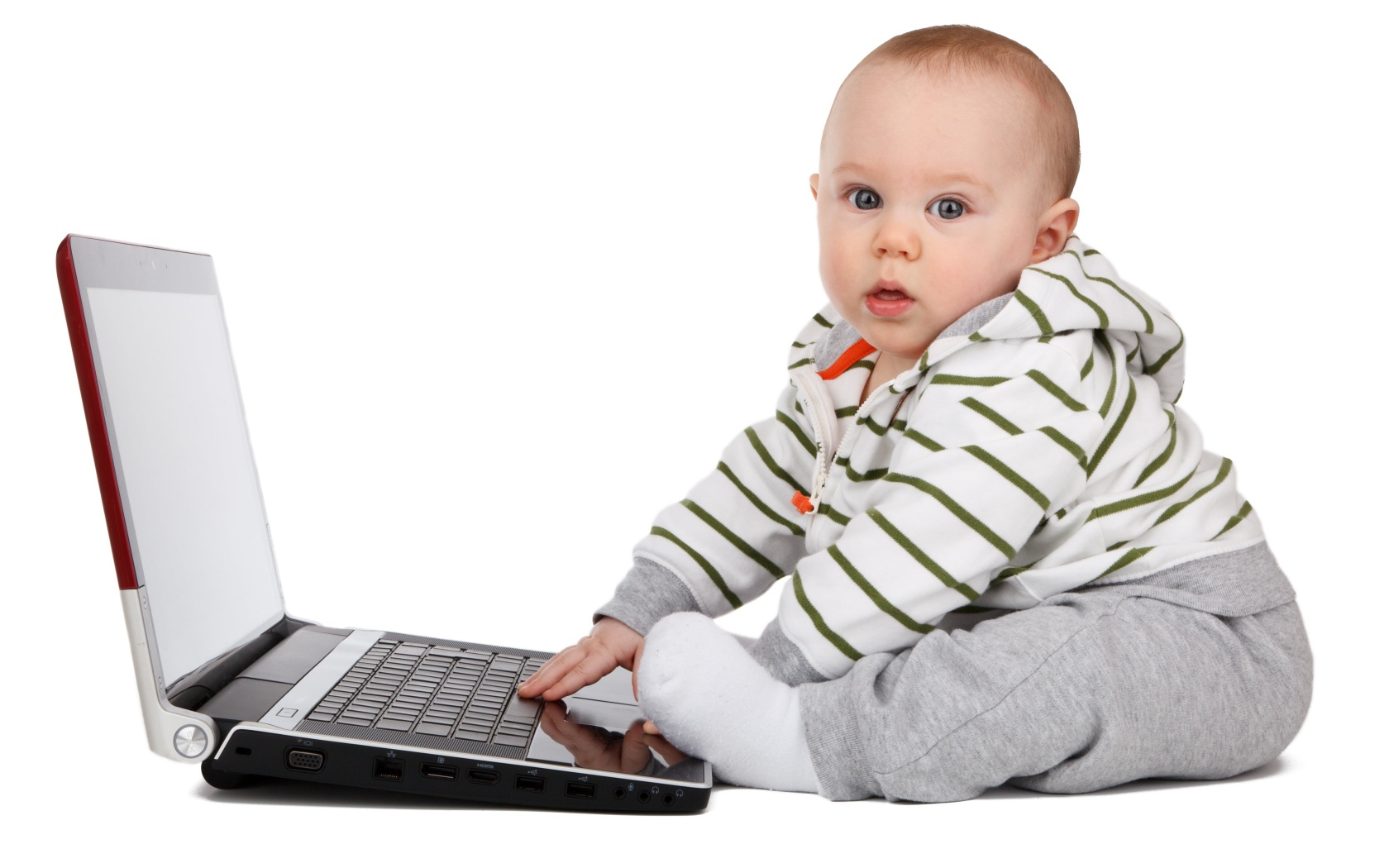 Маленький ребенок сидит с ноутбуком на белом фоне