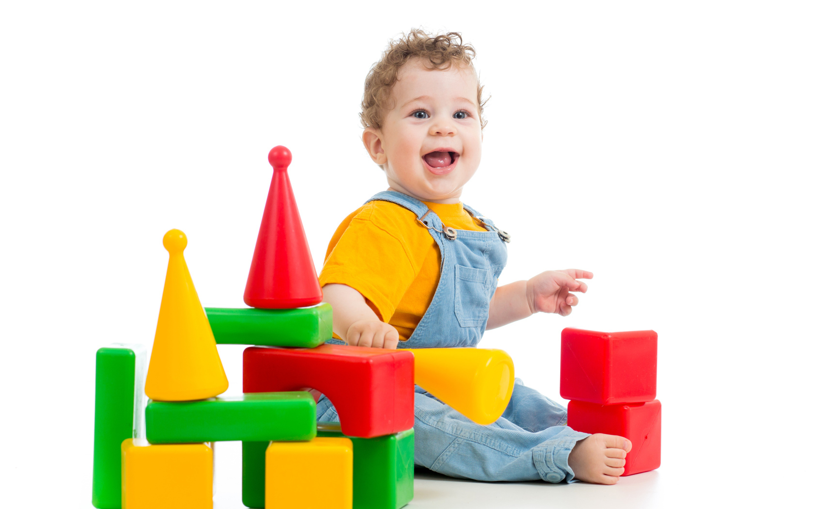 Улыбающийся милый малыш играет с кубиками на белом фоне