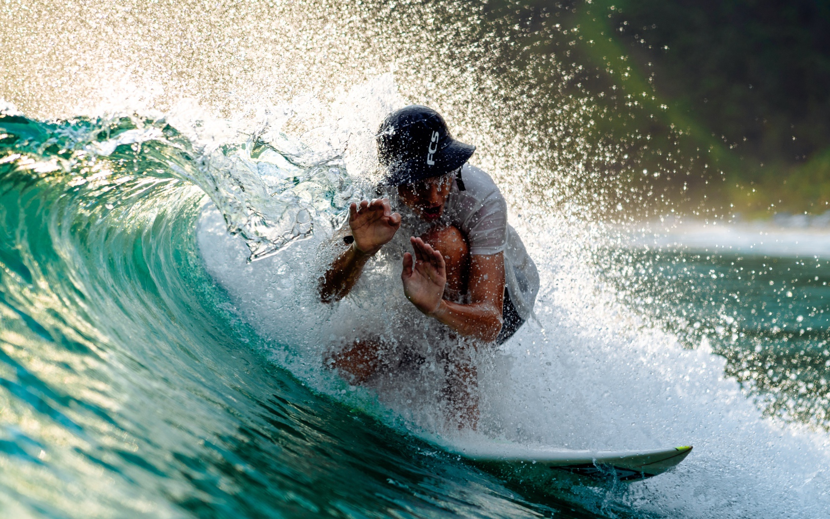 Парень серфингист ловит голубую морскую волну