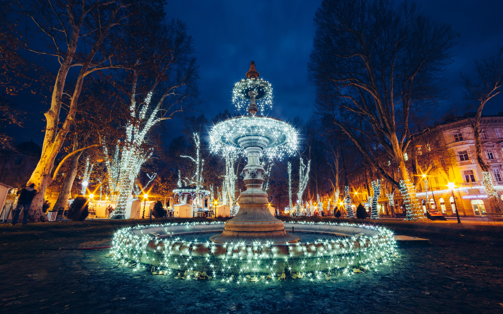 Красивый фонтан с гирляндами в городе вечером