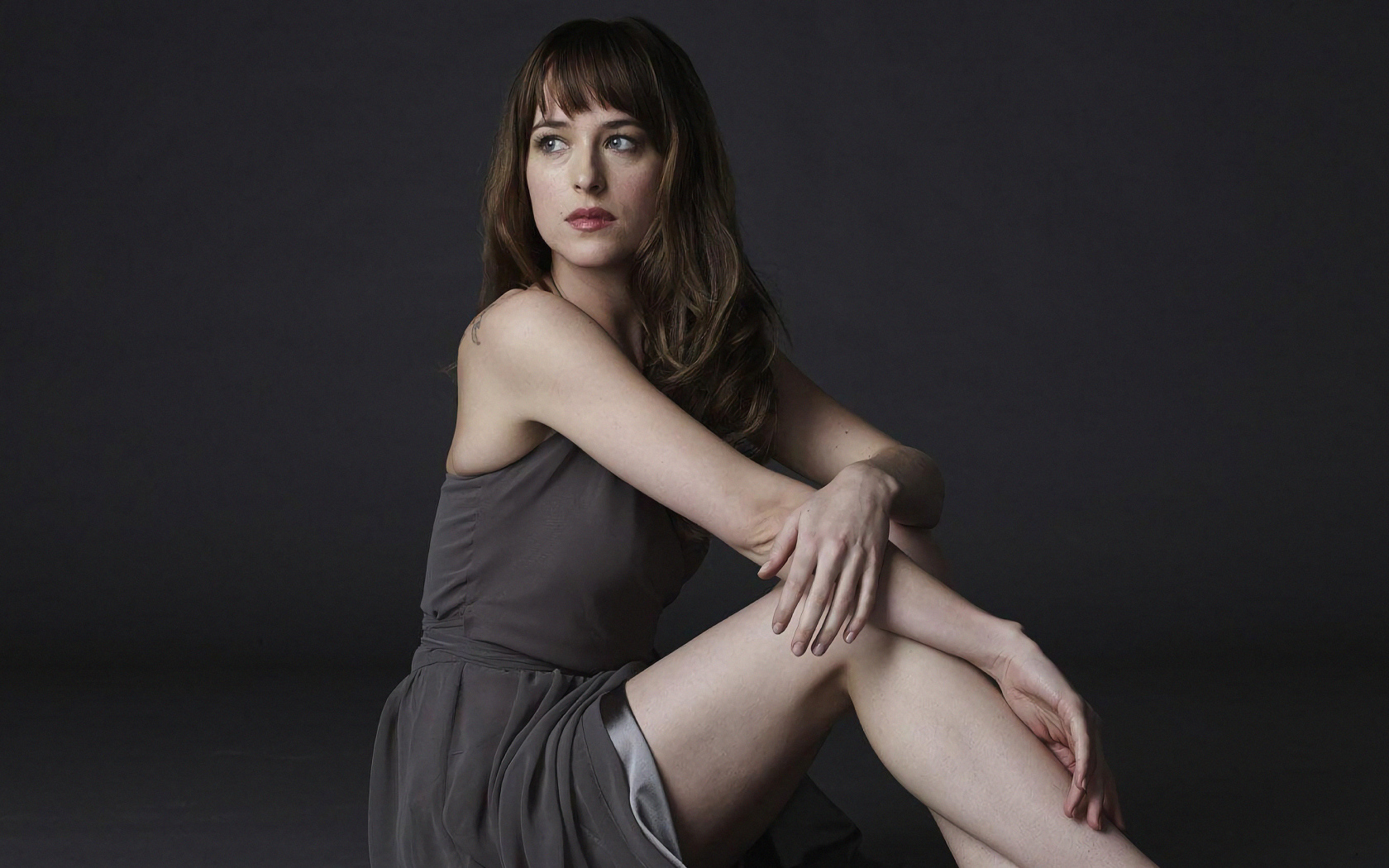 Актриса Дакота Джонсон в платье на сером фоне