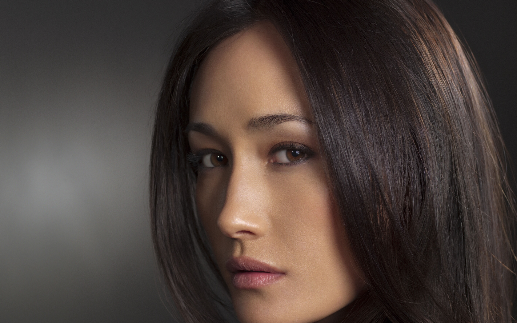 Актриса Мэгги Кью лицо крупным планом на сером фоне