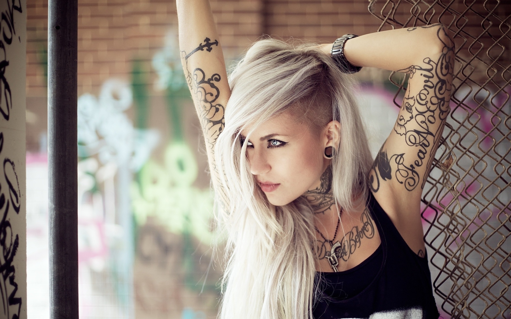 Красивая блондинка с татуировками на теле