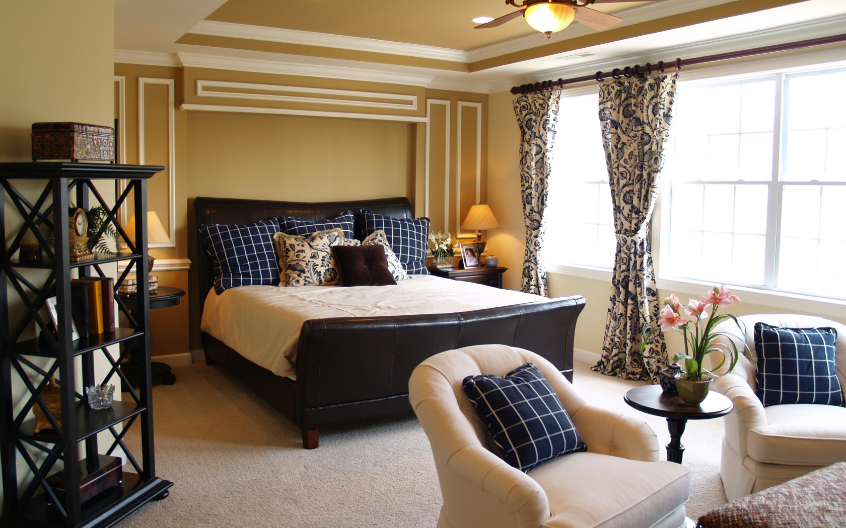 Спальня с большой кожаной кроватью и креслами 