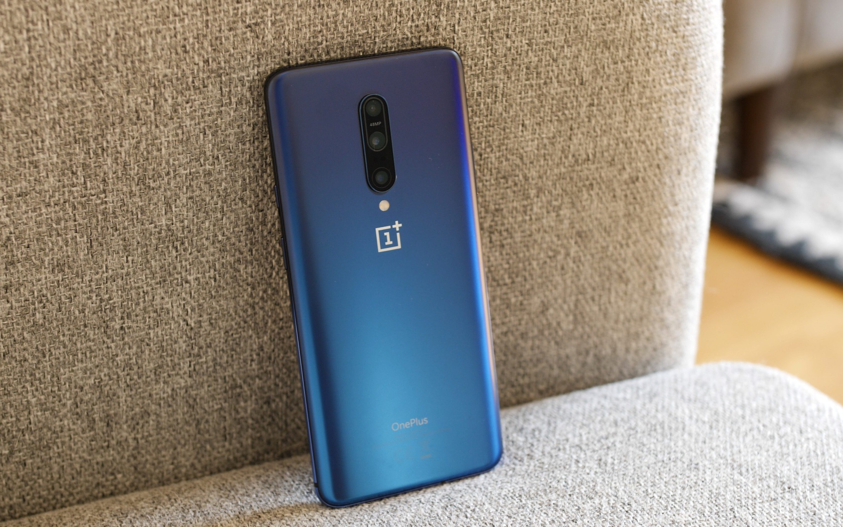 Синий смартфон ONEPLUS 7 на диване