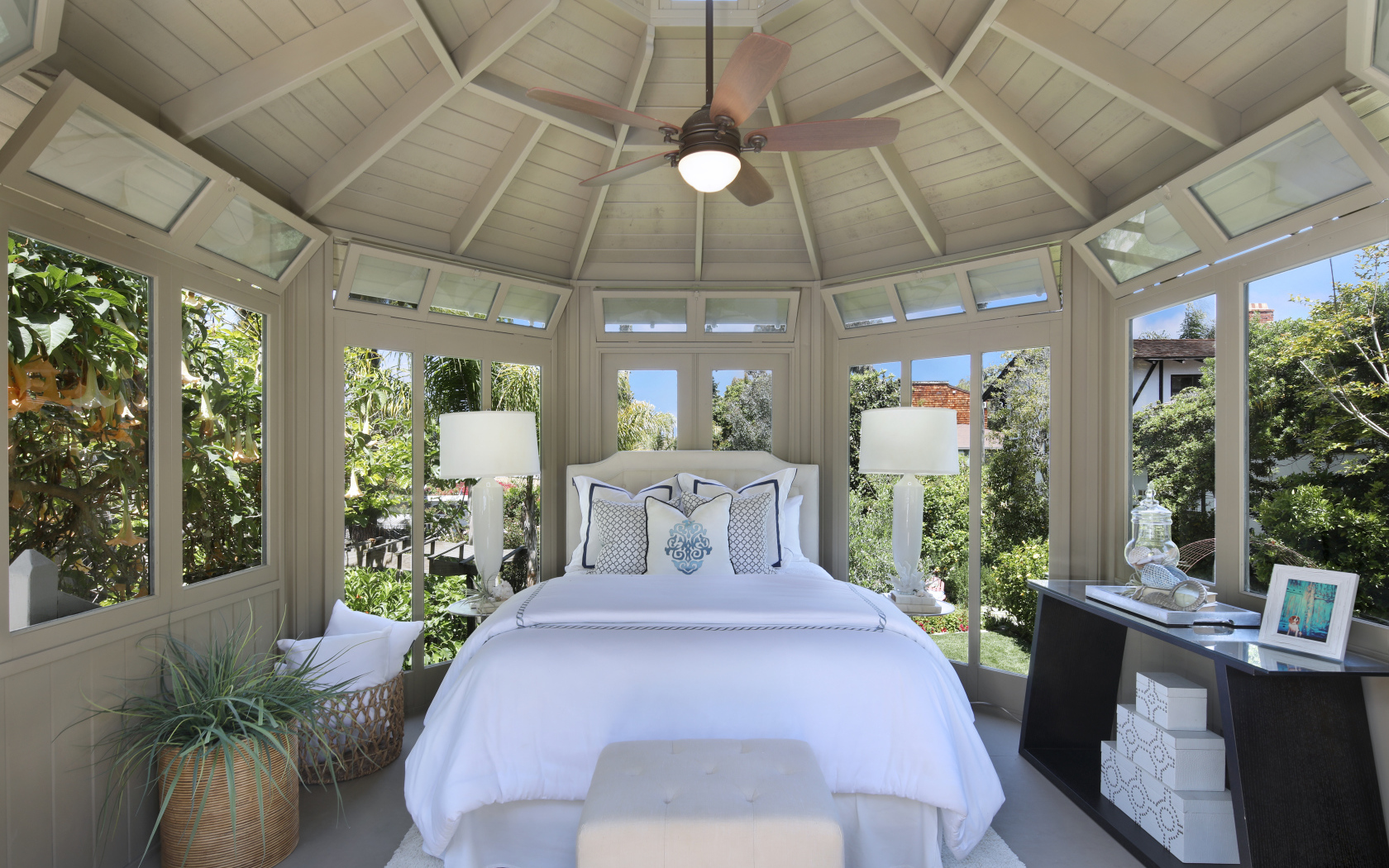 Большая спальная комната с окнами и белой кроватью 