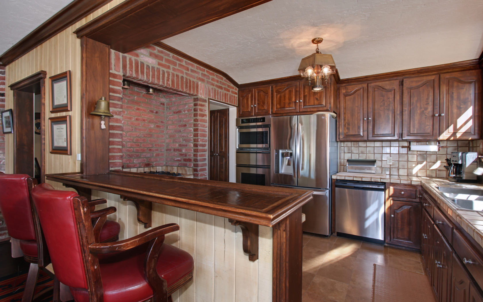 Просторная кухня с деревянной мебелью и кожаными стульями