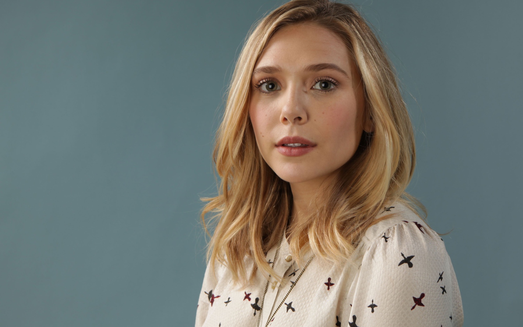 Нежная девушка, актриса Элизабет Олсен на сером фоне