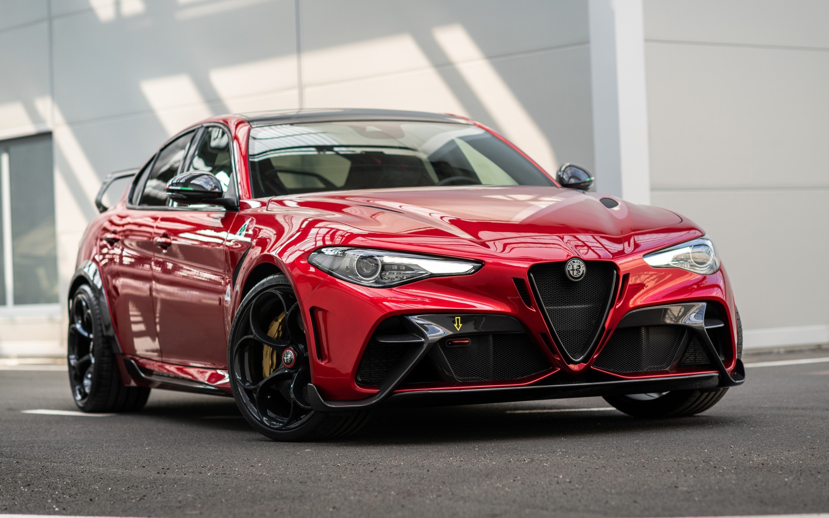 Красный автомобиль Alfa Romeo Giulia GTAm 2020 года у гаража