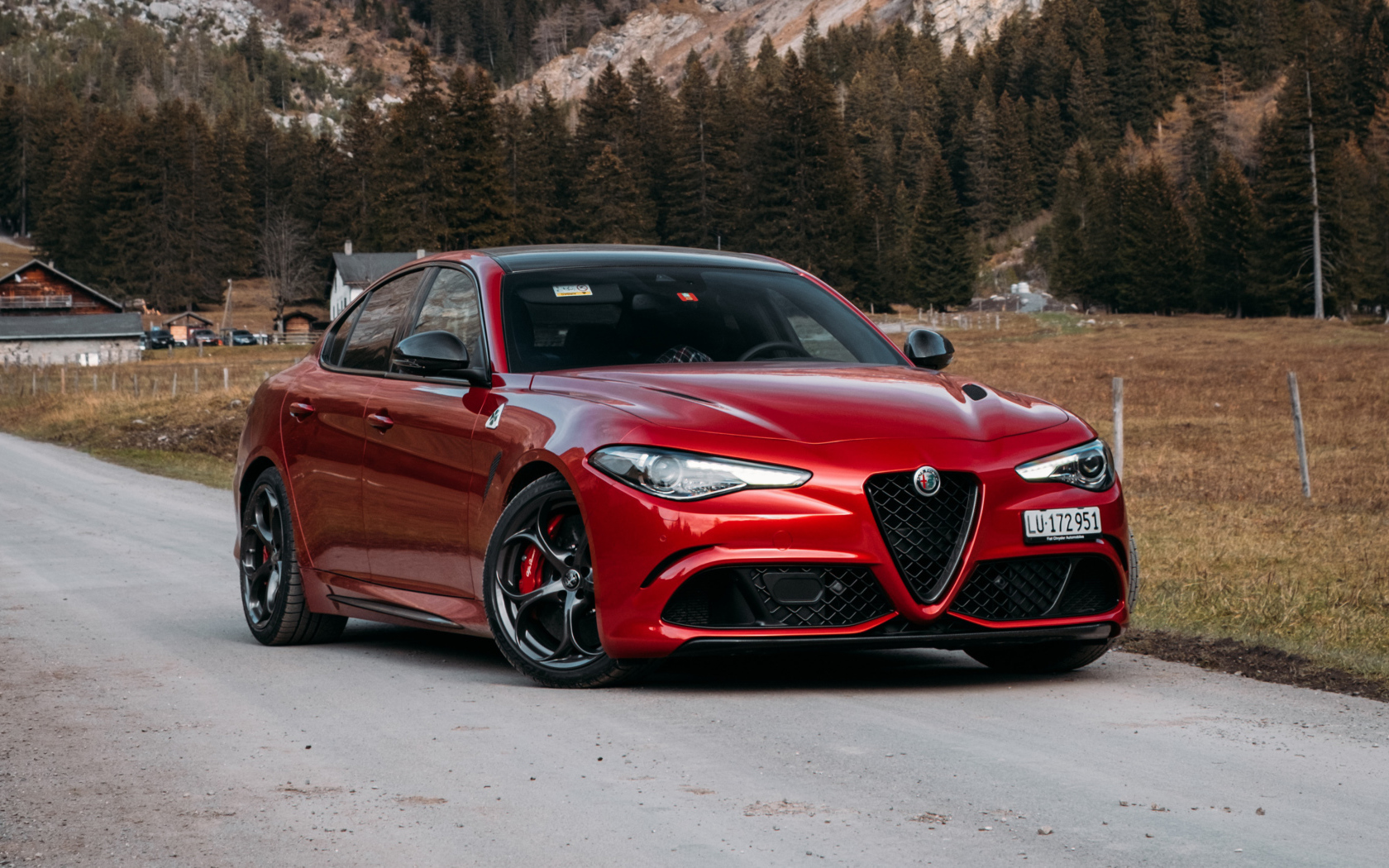 Красный автомобиль Alfa Romeo Giulia Quadrifoglio 2021  года на фоне гор